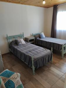 una stanza con due letti e una finestra di La Guarida a Pergamino