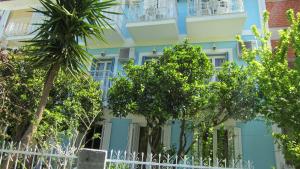 a blue building with trees in front of it at Sandalis Hotel in Pythagoreio