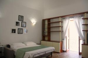 a bedroom with a bed and a window at Caracciolo Lounge in Cefalù