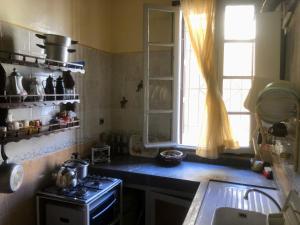 a small kitchen with a stove and a window at Tisra Appartement in Meknès
