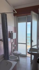 a bathroom with two sinks and a toilet and a balcony at Diplomat Marine in Cattolica