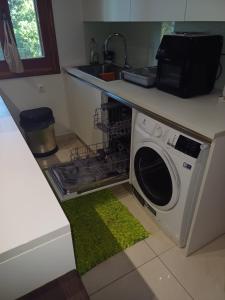 a washing machine in a kitchen with a green rug at Penthouse Ipsos Marina in Ipsos