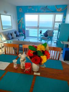 a living room with a table with flowers on it at The Beach Condo in Durban