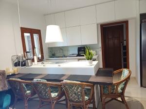 a kitchen with a dining table and chairs in a kitchen at Penthouse Ipsos Marina in Ipsos