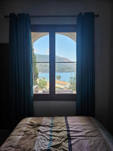 a bedroom with a window with a view of the water at Penthouse Ipsos Marina in Ipsos