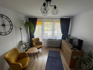 a living room with two chairs and a television at Apartament na Szlakowisku in Starachowice