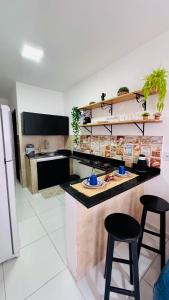 a kitchen with two bar stools and a counter top at Ap5- atrás da Passarela do Caranguejo Atalaia - térreo - 2 ar cond in Aracaju