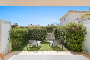a pair of chairs sitting in the yard of a house at Au bout de la rue la Mer- T3 Jardin Piscine PARKING WIFI BY HC in Carqueiranne