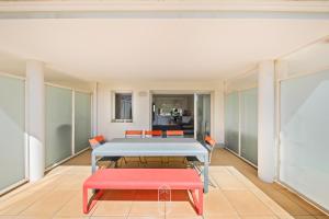 a dining room with a table and two red benches at Au bout de la rue la Mer- T3 Jardin Piscine PARKING WIFI BY HC in Carqueiranne