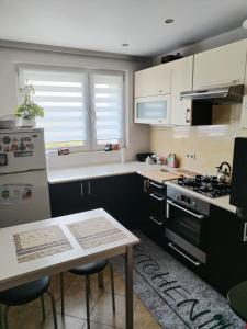 a kitchen with white cabinets and a table and a stove at Apartament na Szlakowisku in Starachowice