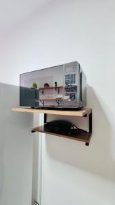 a microwave oven sitting on a shelf next to a wall at Ap5- atrás da Passarela do Caranguejo Atalaia - térreo - 2 ar cond in Aracaju