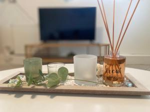 a tray with three glasses and a vase on a table at Seaside & Pool Apartments in Káto Ássos