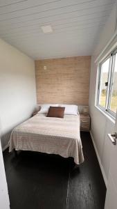 Un dormitorio con una cama en una habitación con ventana. en Saint Saus - Casa en Sauce de Portezuelo, Maldonado, en Maldonado