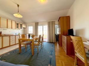 Una cocina y un comedor con mesa y sillas. en Stella Maris, en Kukljica