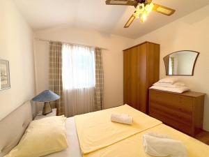 Un dormitorio con una cama, una cómoda y un espejo. en Stella Maris, en Kukljica