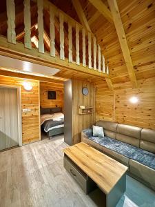 a living room with a couch and a bed in a cabin at Eternum Glamping in Žabljak
