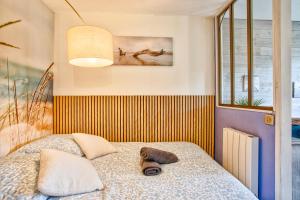 ein Schlafzimmer mit einem Bett, auf dem ein Hut liegt in der Unterkunft Les Dunes - Jardin Privatif - Plage à 500 Mètres in Merville-Franceville-Plage