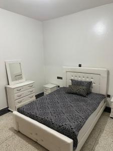 a bedroom with a bed with a mirror and a dresser at Appartement Ritage in Meknès
