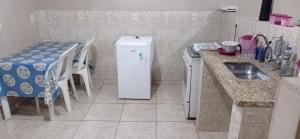 a small kitchen with a refrigerator and a table at Residencial Barbosa - Apto 301 in Macaé