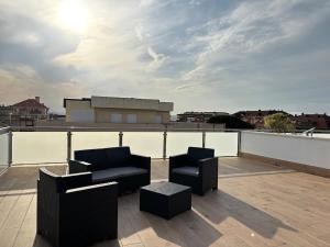 a patio with two chairs and tables on a roof at Casa Mouro Somo - Surf y playa in Somo