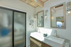 een badkamer met een wastafel en een spiegel bij Luxury Ocean Front Cambria Beach House in Cambria +59 foto's