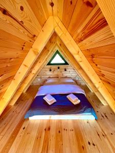 a bed in a wooden room in a tree house at Eternum Glamping in Žabljak