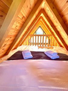 a large bed in a wooden attic bedroom at Eternum Glamping in Žabljak