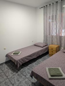 a room with two beds and a table and a window at Casa M&D in Lloret de Mar +13 photos