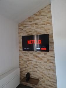 a television mounted on a brick wall at Logement au cœur du village in Tourtour
