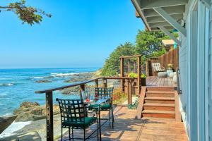 een terras met een tafel en stoelen en de oceaan bij Luxury Ocean Front Cambria Beach House in Cambria