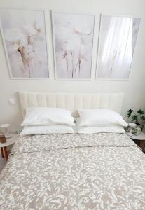 a bedroom with a bed with two paintings on the wall at Jasmine Home, Aegina City in Aegina Town