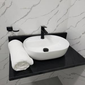 a white sink on a black counter in a bathroom at The KWASU Apartments in Chipata +87 photos