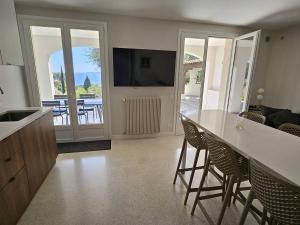 Il comprend une cuisine avec une table et des chaises ainsi qu'un salon. dans l'établissement Rez de villa avec piscine privée chauffée et jardin, à 1 km de la mer - FR-1-768-79, à Saint-Peïre-sur-Mer