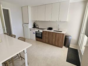 - une cuisine avec des placards blancs, un évier et une table dans l'établissement Rez de villa avec piscine privée chauffée et jardin, à 1 km de la mer - FR-1-768-79, à Saint-Peïre-sur-Mer