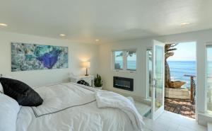 een slaapkamer met een bed en uitzicht op de oceaan bij Luxury Ocean Front Cambria Beach House in Cambria