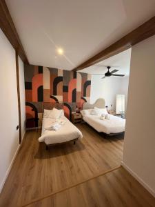 サン・セバスティアンにあるKaixo Roomsのベッド2台が備わる客室で、壁には壁画があります。