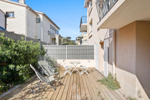 a patio with two chairs and a table on a deck at Appartement 3 étoiles coquet à 700m de la mer Les Bonnettes WiFi PK BY HC in Le Pradet