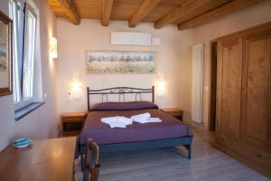 a bedroom with a bed with purple sheets and a table at Scorci Di Mare in Riomaggiore