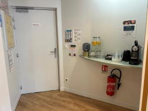 a white door in a room with a counter and a shelf at Hôtel Marguerite in Dinan