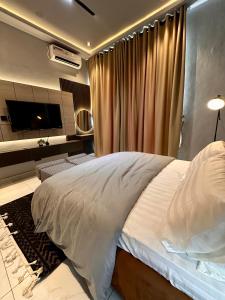 Un dormitorio con una cama grande y un televisor. en emerald, en Lagos 5 fotos más