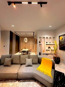 Una sala de estar con un sofá gris y una manta amarilla. en emerald, en Lagos
