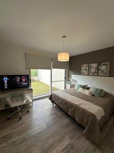 Un dormitorio con una cama grande y un televisor de pantalla plana. en Suites de Portal, en Paraná