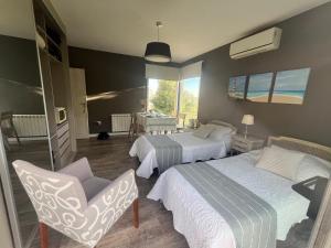 Un dormitorio con dos camas y una silla. en Suites de Portal, en Paraná 28 fotos más