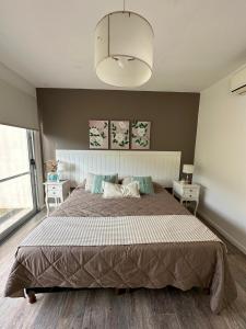 Un dormitorio con una cama grande y una ventana grande. en Suites de Portal, en Paraná