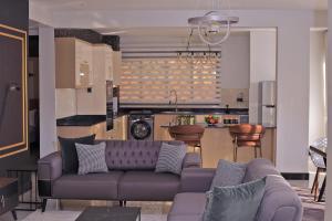 a living room with a couch and a kitchen at 2 Bedroom Jonarrick Apartments Kisaasi in Kampala