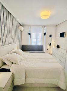 ein weißes Schlafzimmer mit zwei Betten und einem Fenster in der Unterkunft En PLENO CENTRO - Especial para GRUPOS o FAMILIAS - GRAN VÍA - CALLAO - SOL - PLAZA ESPAÑA in Madrid