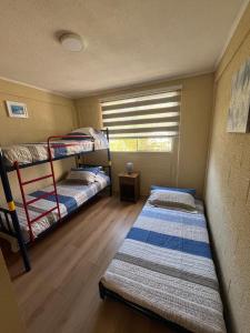 two bunk beds in a room with a window at Elqui Antu in Vicuña