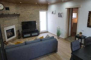 ein Wohnzimmer mit einem blauen Sofa und einer Ziegelwand in der Unterkunft Casal da FontAgrão in Rio Maior