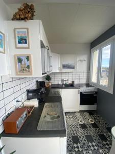 a kitchen with white cabinets and a black counter top at Entre terre & Mer in Saint-Brieuc