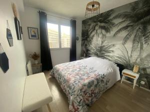 a bedroom with a bed with a tropical wallpaper at Entre terre & Mer in Saint-Brieuc